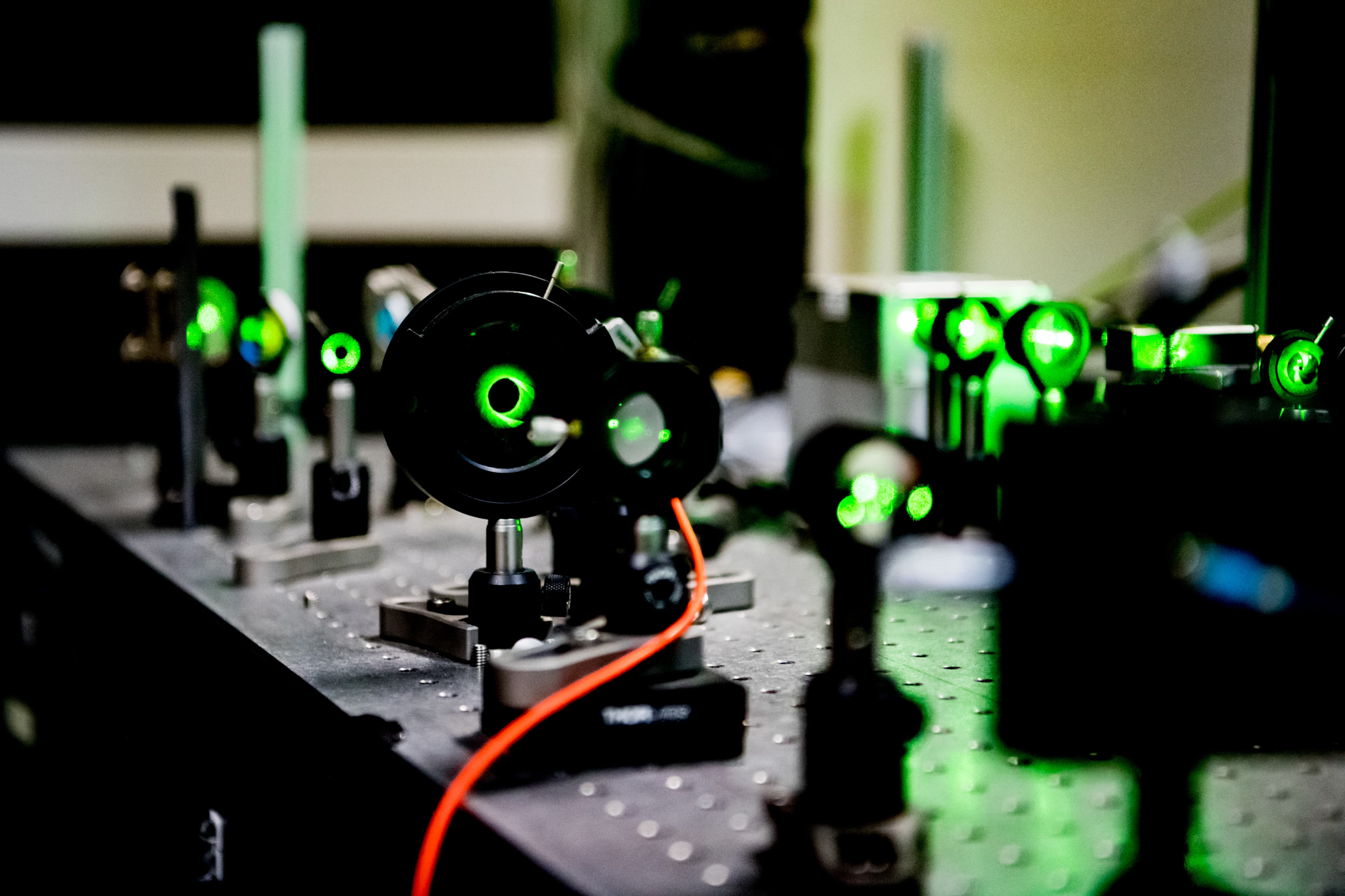 Details showing guiding of the 532nm laser beam used for NV spin polarization and readout. The beam is directed onto the quantum chip consisting of a diamond plate  equipped with electrical contacts and MW strip lines for spin state manipulation (not shown).